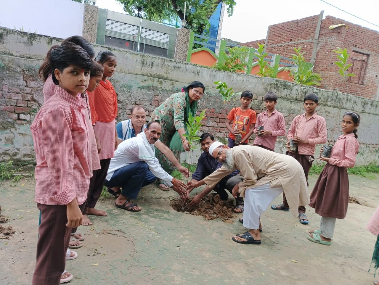 School children plant a sapling with local residents