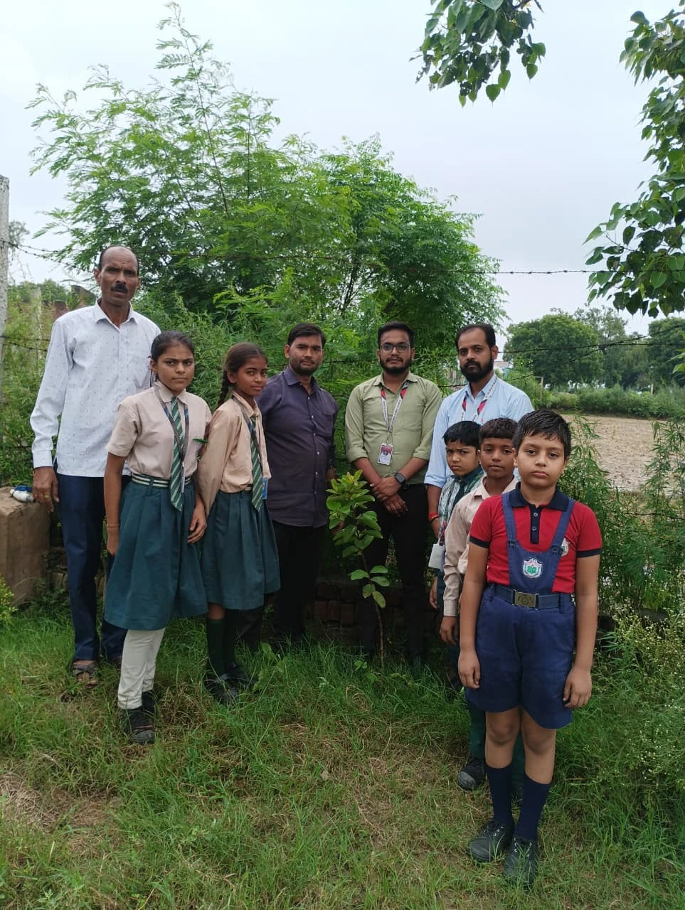 Children beside the sapling they adopted